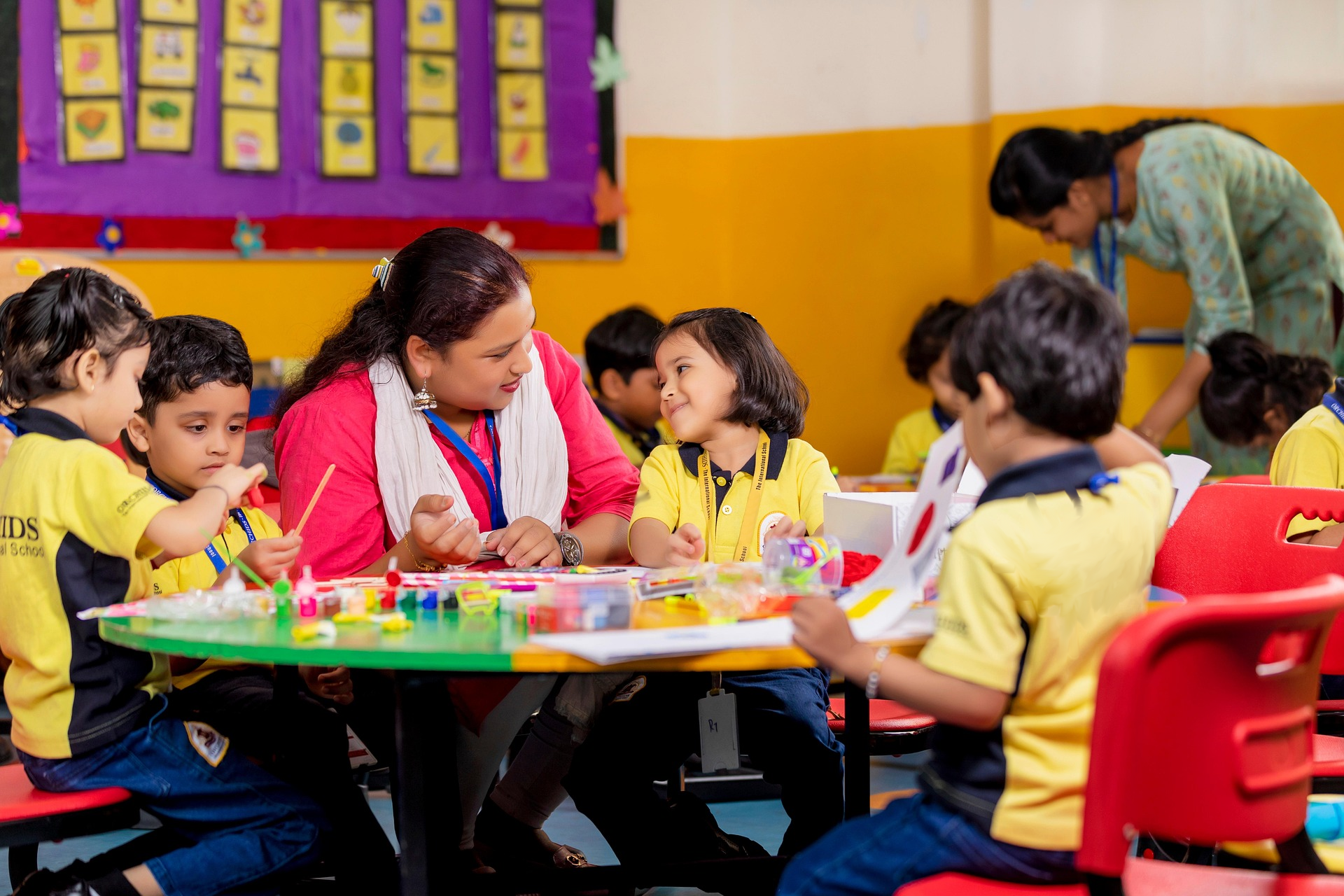 Teacher guiding young students in a classroom, representing holistic and values-based child education in India