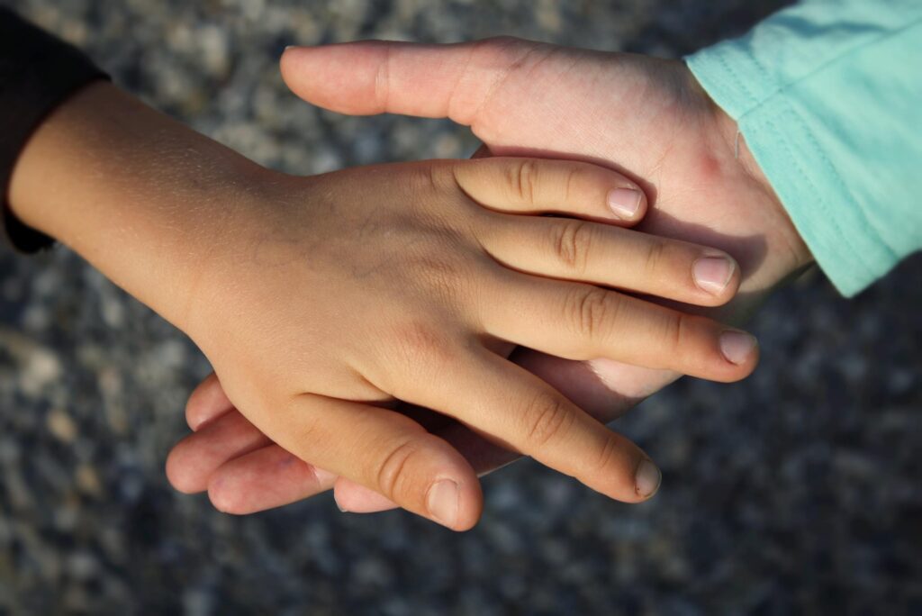 Two hands joined together symbolizing compassion, partnership, and values-based child education in India