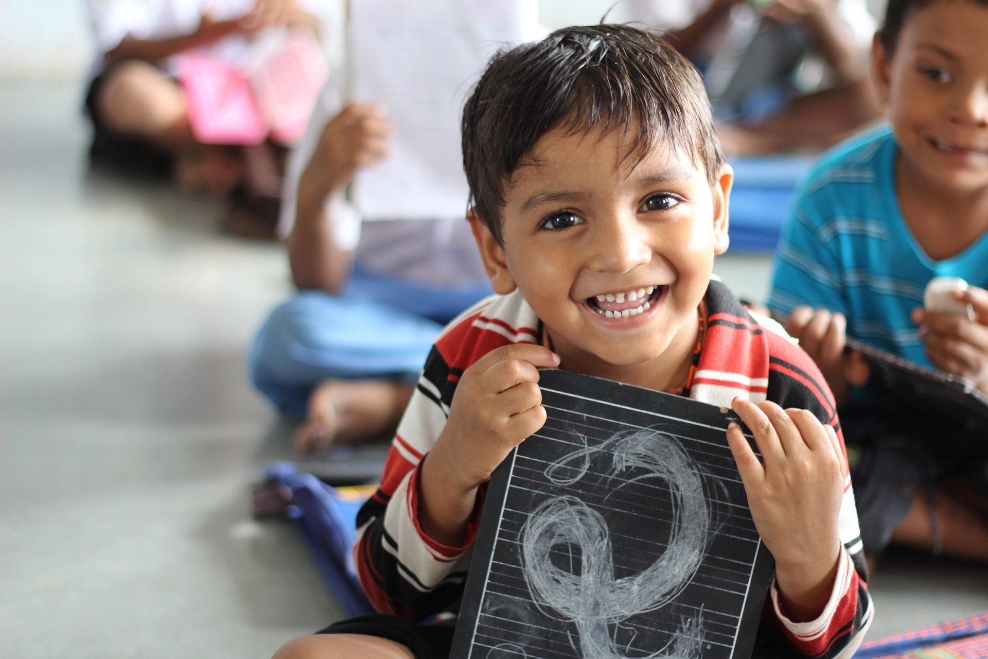 Smiling child learning in a classroom — equal access to education, CTFIF