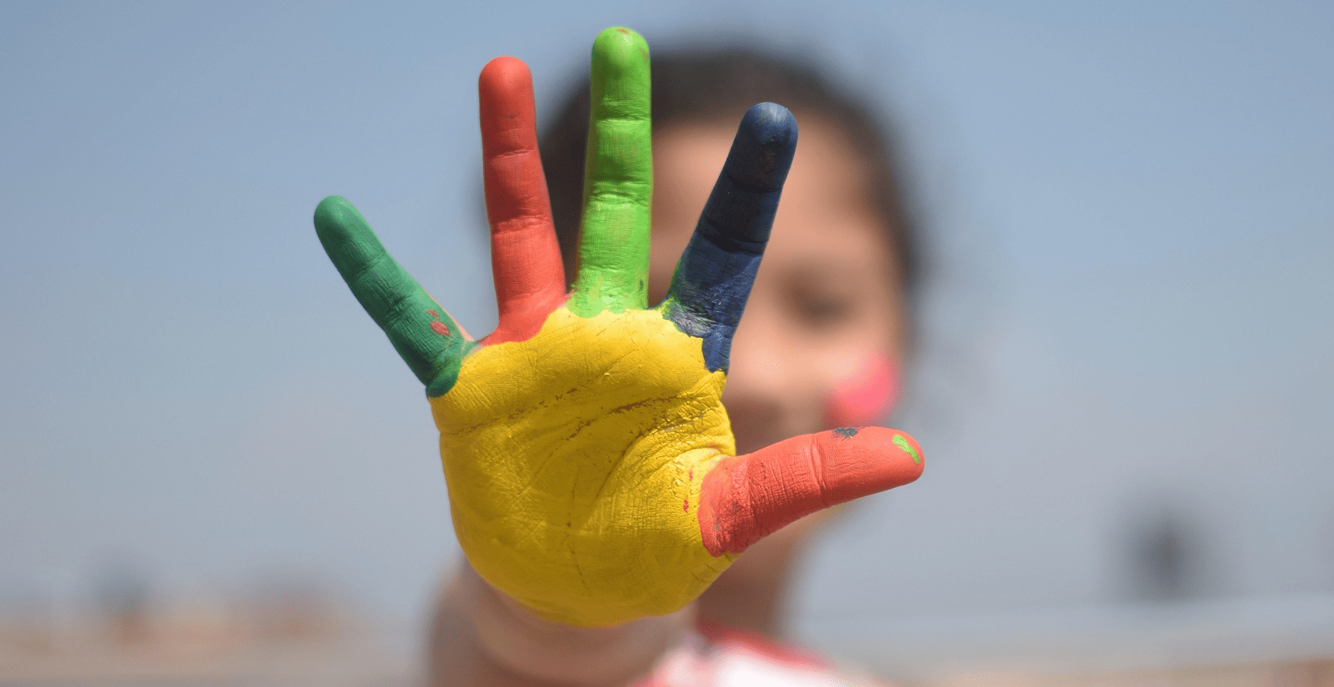 Child’s palm painted in bright colors symbolizing creativity, diversity, and holistic education in India